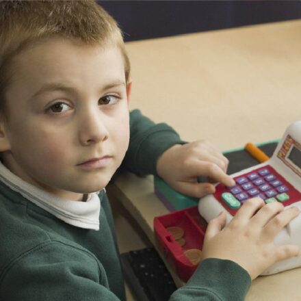 young boy playing with a till (Devon's SEND Local Offer)