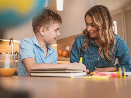 a teacher and a school age boy working together in a classroom