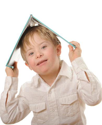 portrait photo of a young boy with a book on is head