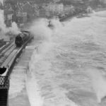 The sea washing over a train travelling on the coastal trainline