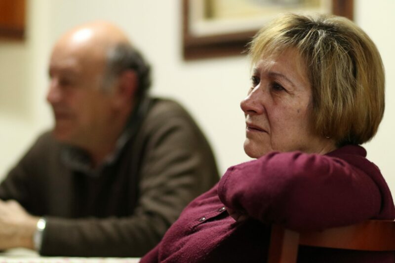 man and woman sat at a table. Woman looks anxious.