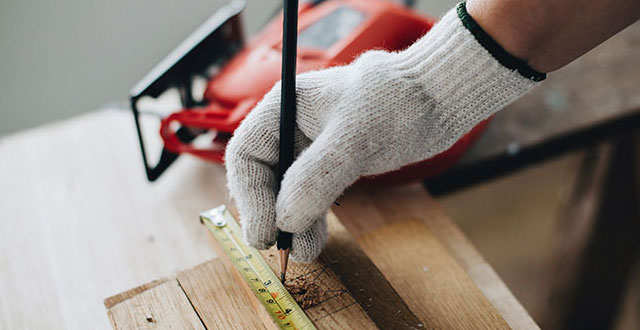 A tradesman measuring some wood