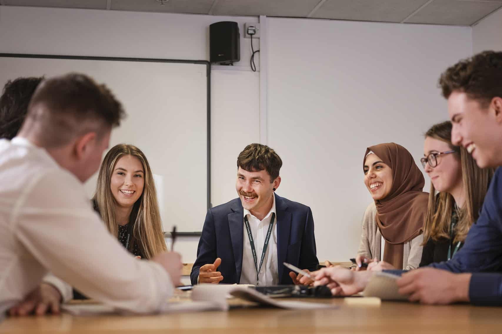 Young people in a business setting sitting around a table