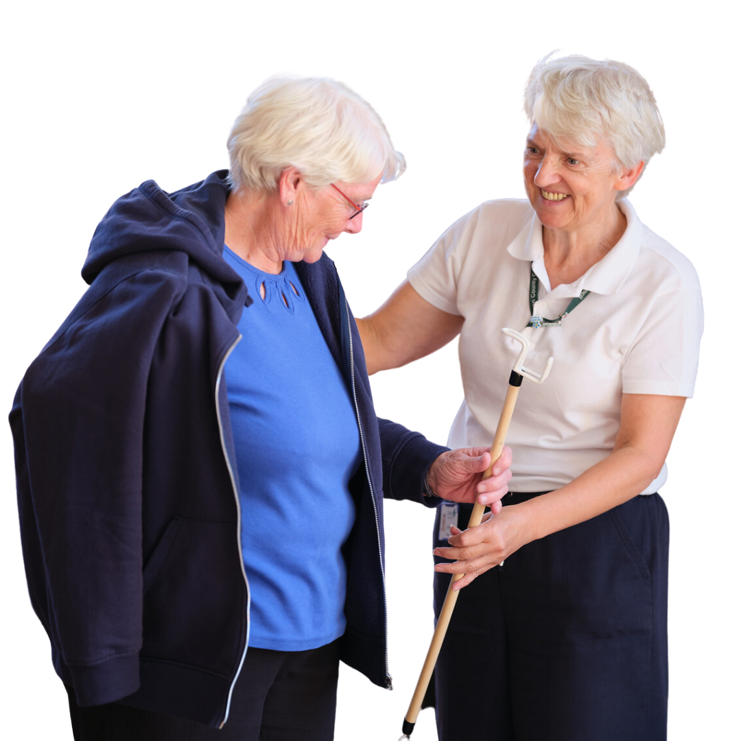 A person assists an older person in putting a jacket on.